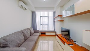 A modern living room with a sofa, TV, and built-in shelves. - Elegant And Nice 2Br At L'Avenue Pancoran Apartment (Jakarta)