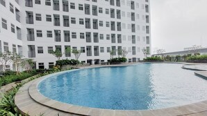 Un edificio moderno con piscina rodeada de vegetación.