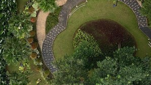 Vue aérienne d’un jardin aménagé, avec une zone centrale circulaire, entourée d’un sentier sinueux et de différentes espèces de plantes.