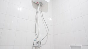 Une douche équipée d’un pommeau de douche à main et d’un robinet fixé au mur.
