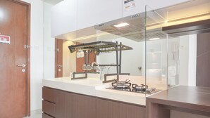 Une cuisine moderne dotée d’une cuisinière intégrée, d’un évier et d’une protection en verre pour la cuisinière.