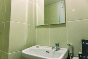 A bathroom with a sink, mirror, and toiletries. - Fancy And Serene 1Br Apartment At M-Town Residence (Gading Serpong)
