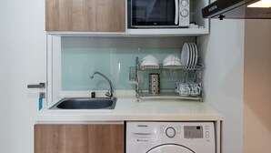 A compact kitchen with a microwave, dishwasher, and sink.