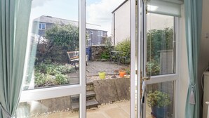 Una stanza con un'ampia porta scorrevole in vetro che si apre su un patio esterno.