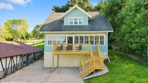 A two-story house with a front porch, a garage, and a small deck.