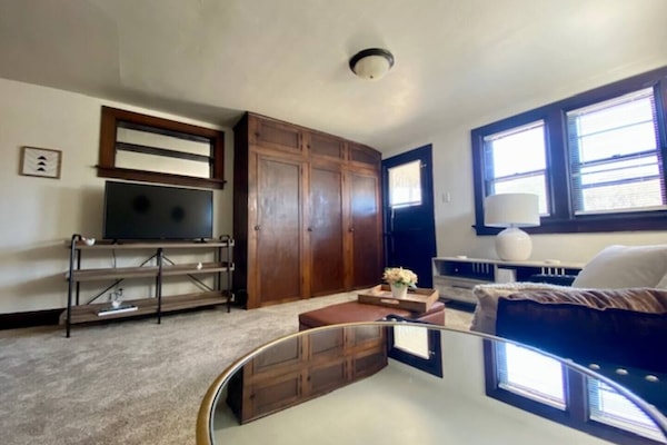 Spacious living room with built in closet for storage and private access to a small second floor patio.