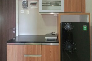 Compact kitchen with a modern design, featuring a refrigerator, microwave, and printer.