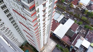 A high-rise building with multiple balconies and a rooftop garden. - Cozy And High Floor Studio Room At Vida View Makassar Apartment (Makassar)