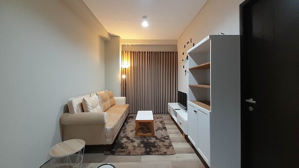 A modern living room with a sofa, a coffee table, and a TV stand.