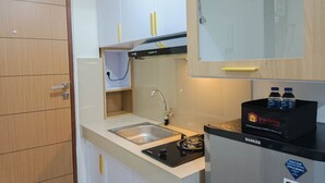 Eine kompakte Küche mit Spüle, Herd und Kühlschrank mit einem Fach der Marke travelio.