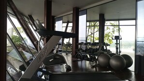 Ein Fitnessraum mit Laufband, Kurzhanteln und Trainingsbällen.