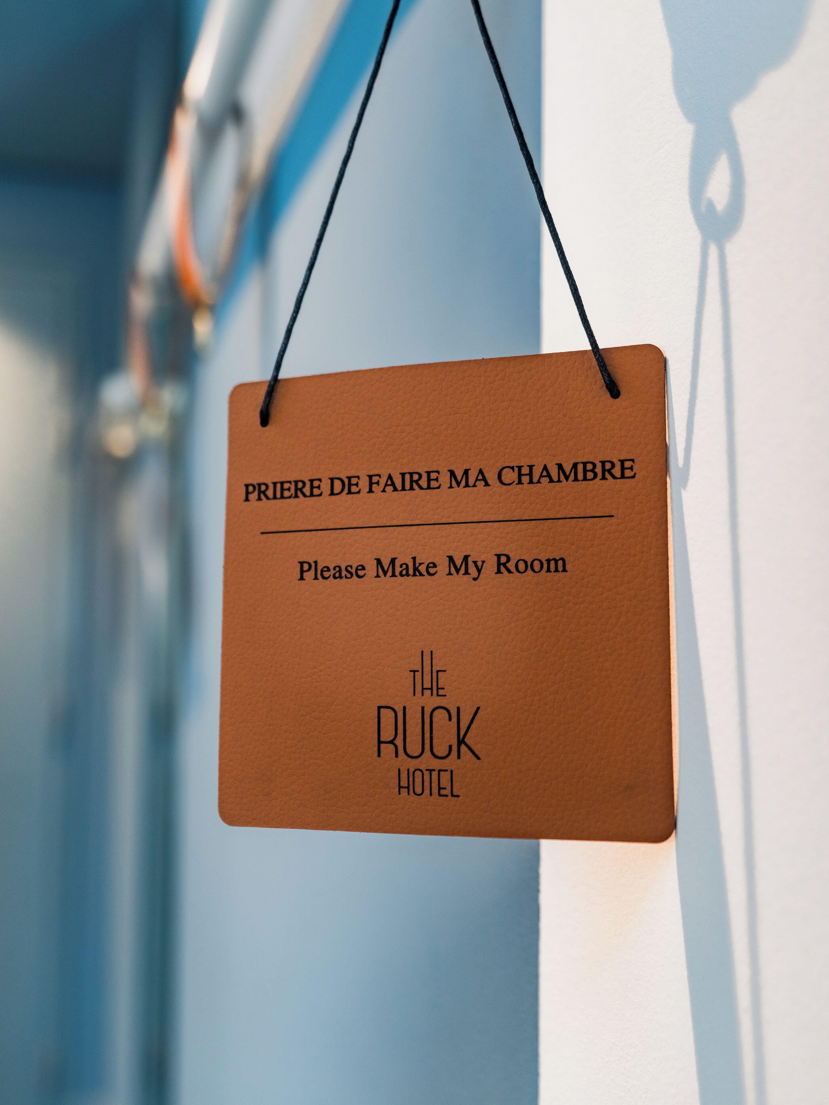 Een bord met de tekst 'Maak mijn kamer gereed' en 'The Ruck Hotel', wat aangeeft dat er een verzoek voor roomservice is.
