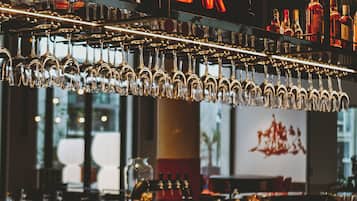 A bar with a neon sign reading "The Ruck Bar" and various bottles and glasses on shelves.