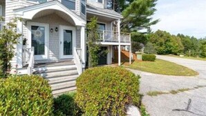 A two-story house with a front porch, a covered entryway, and a driveway.
