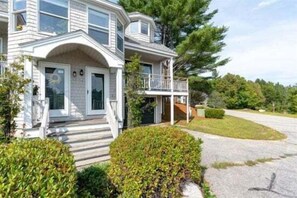 A two-story house with a front porch, a covered entryway, and a driveway.
