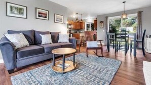 A modern living room with a sofa, coffee table, and dining area.