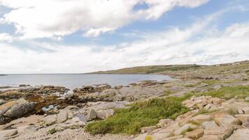 A rocky coastal landscape with a clear sky and calm sea.