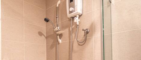 Una ducha moderna con un cabezal de ducha de mano, un cabezal de ducha fijo y un accesorio de ducha manual.