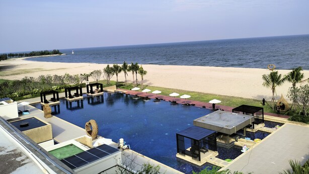 A pool area with a view of the beach and ocean. - Sea Sand Sun Hua Hin by JC Kevin Hotel & Resort (Cha-am)