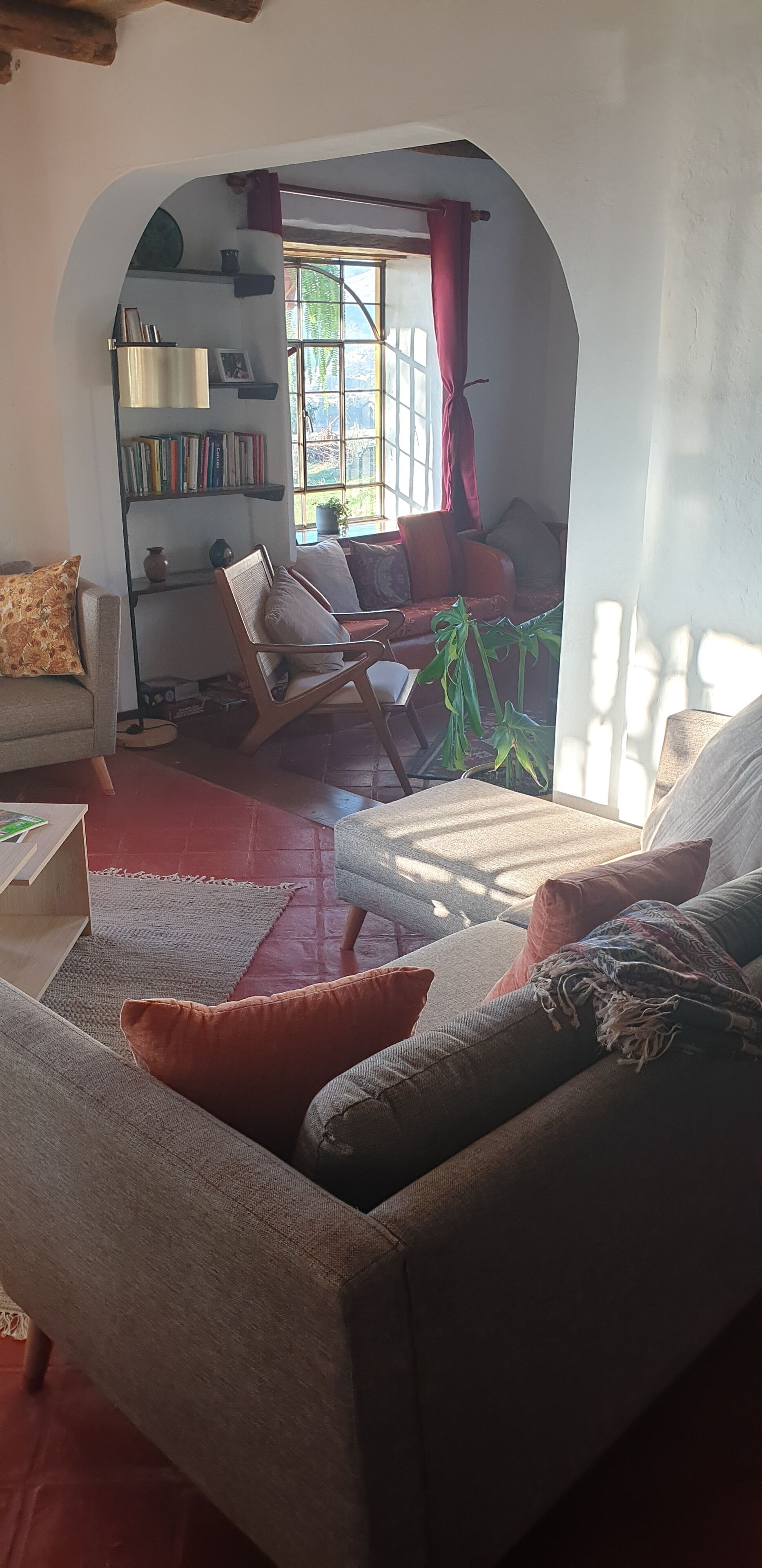 En hyggelig stue med en sofa, lænestole og en bogreol.