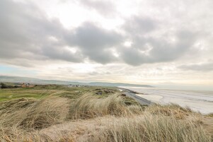Un paisaje costero con dunas y una playa.