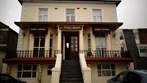 A two-story building with a sign reading "Guest House" above the entrance. - Second Home (London)