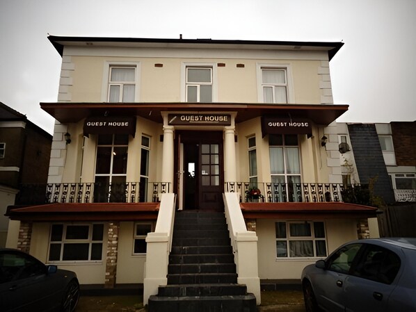 A two-story building with a sign reading "Guest House" above the entrance.