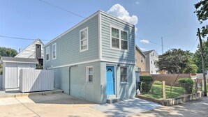 Uma casa de dois andares com porta azul e uma pequena garagem anexa.