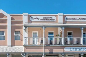 Ein Gebäude mit Schildern für „Quality Executive Accommodation“ und „Foreshore Apartments“.