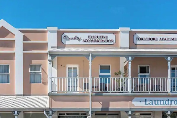Een gebouw met borden waarop 'Quality Executive Accommodation' en 'Foreshore Apartments' staan.