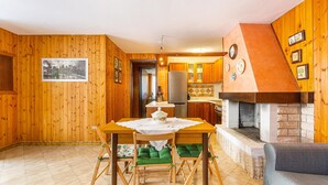 A wooden interior with a dining table, chairs, a fireplace, and a kitchen area. - 3119 A Casa di Giulia e Sofia by Barbarhouse (Racale)