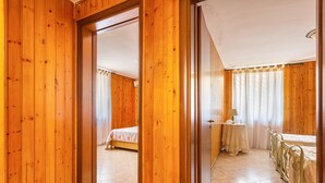 A wooden-paneled room with a bed, a table, and a chair. - 3119 A Casa di Giulia e Sofia by Barbarhouse (Racale)