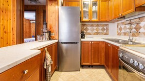 A kitchen with wooden cabinets, a stainless steel refrigerator, a stove, and a tiled backsplash. - 3119 A Casa di Giulia e Sofia by Barbarhouse (Racale)