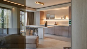 Una cocina moderna con una isla central, taburetes de bar e iluminación colgante.