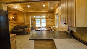Ein Holzblockhaus mit Küche, Essbereich und Wohnzimmer.