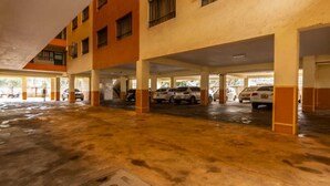 Un parking à plusieurs niveaux, avec plusieurs voitures stationnées sous des abris.