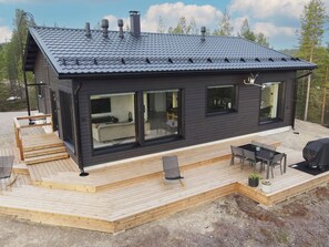 A modern cabin with a deck, large windows, and a chimney. - Villa horihane by Interhome (Inari)