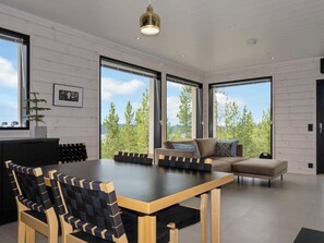 A modern interior with a dining area, a sofa, and large windows. - Villa horihane by Interhome (Inari)
