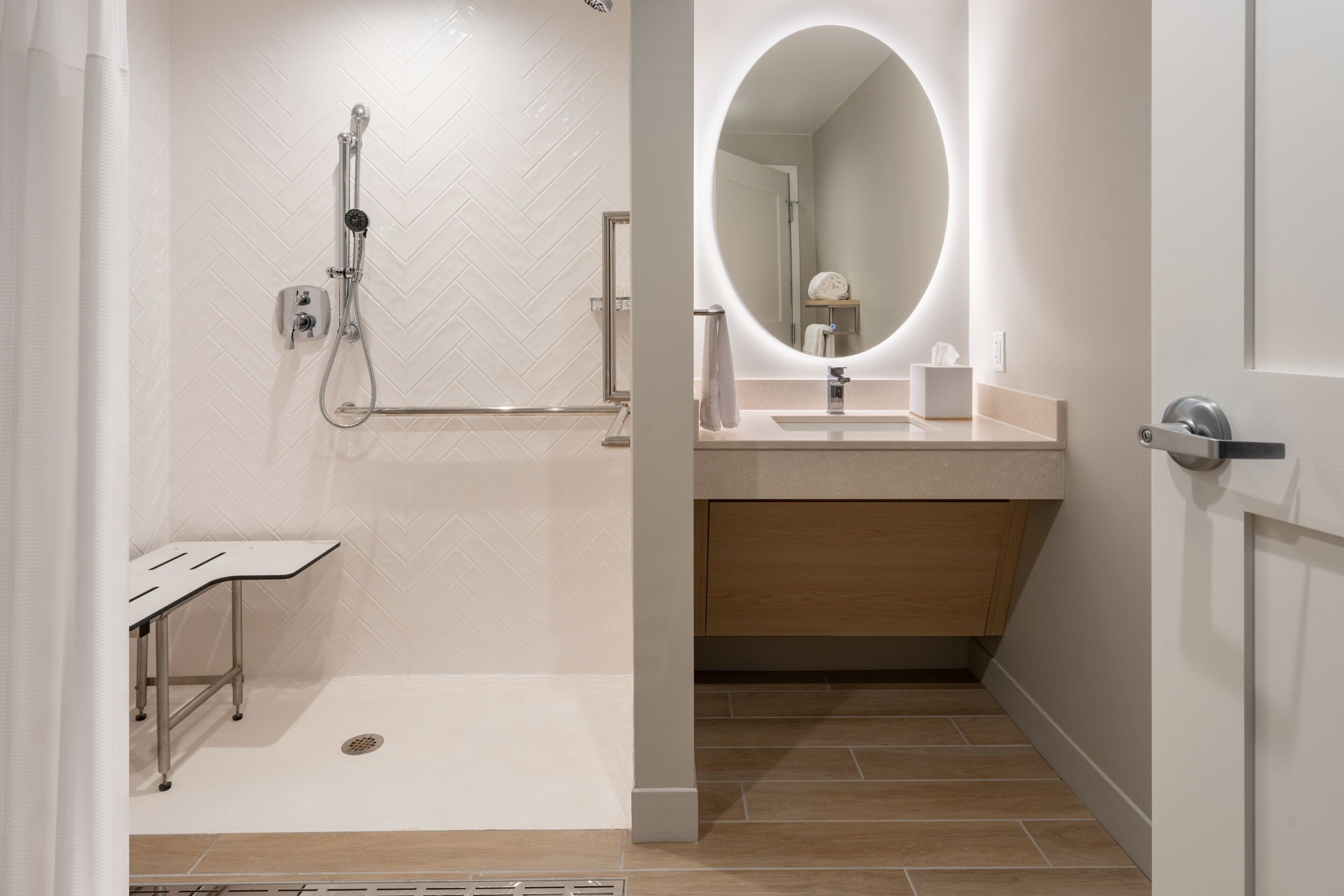 Une salle de bain moderne avec une douche, un meuble-lavabo avec un miroir et des toilettes.