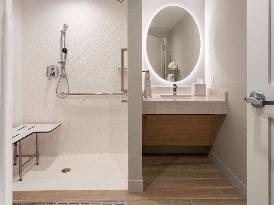 A modern bathroom with a shower, a vanity with a mirror, and a toilet.