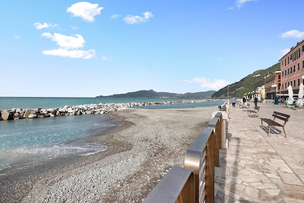A pebble beach with a stone walkway, benches, and buildings along the coast. - Apartment close to the Sea with Sea View & Wi-Fi (Chiavari)