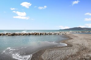 A beach with a rocky shoreline, calm water, and a distant mountain. - Apartment close to the Sea with Sea View & Wi-Fi (Chiavari)