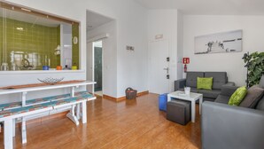 Un área de estar moderna con un sofá, una mesa baja, un banco y un espejo grande.