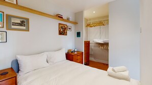 A neatly arranged bedroom with a bed, bedside tables, a dresser, and a walk-in closet. - UK.LO.DCR - Spacious 1 bedroom apartment in Kennington (London)