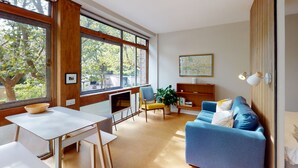 A modern living room with a blue sofa, a white table, and a TV. - UK.LO.DCR - Spacious 1 bedroom apartment in Kennington (London)
