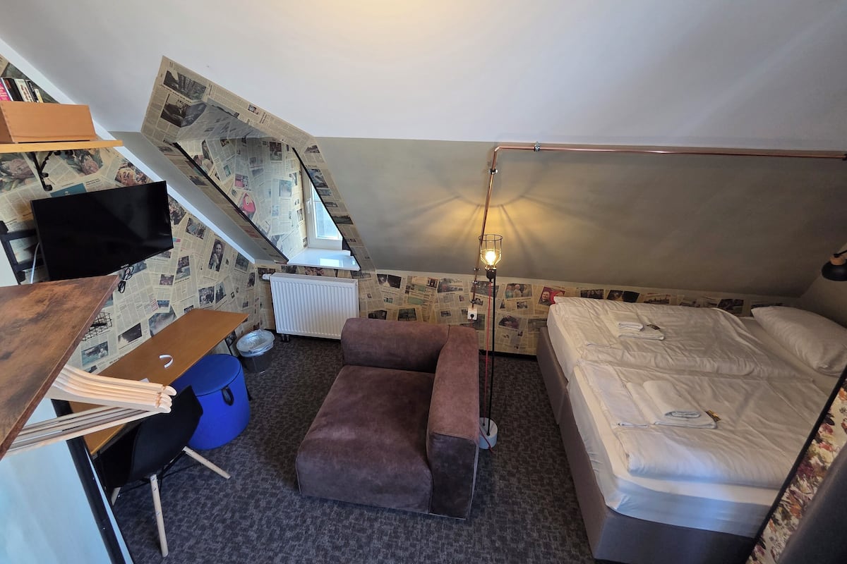Una habitación pequeña con una cama en literas, un escritorio, una silla y un radiador.