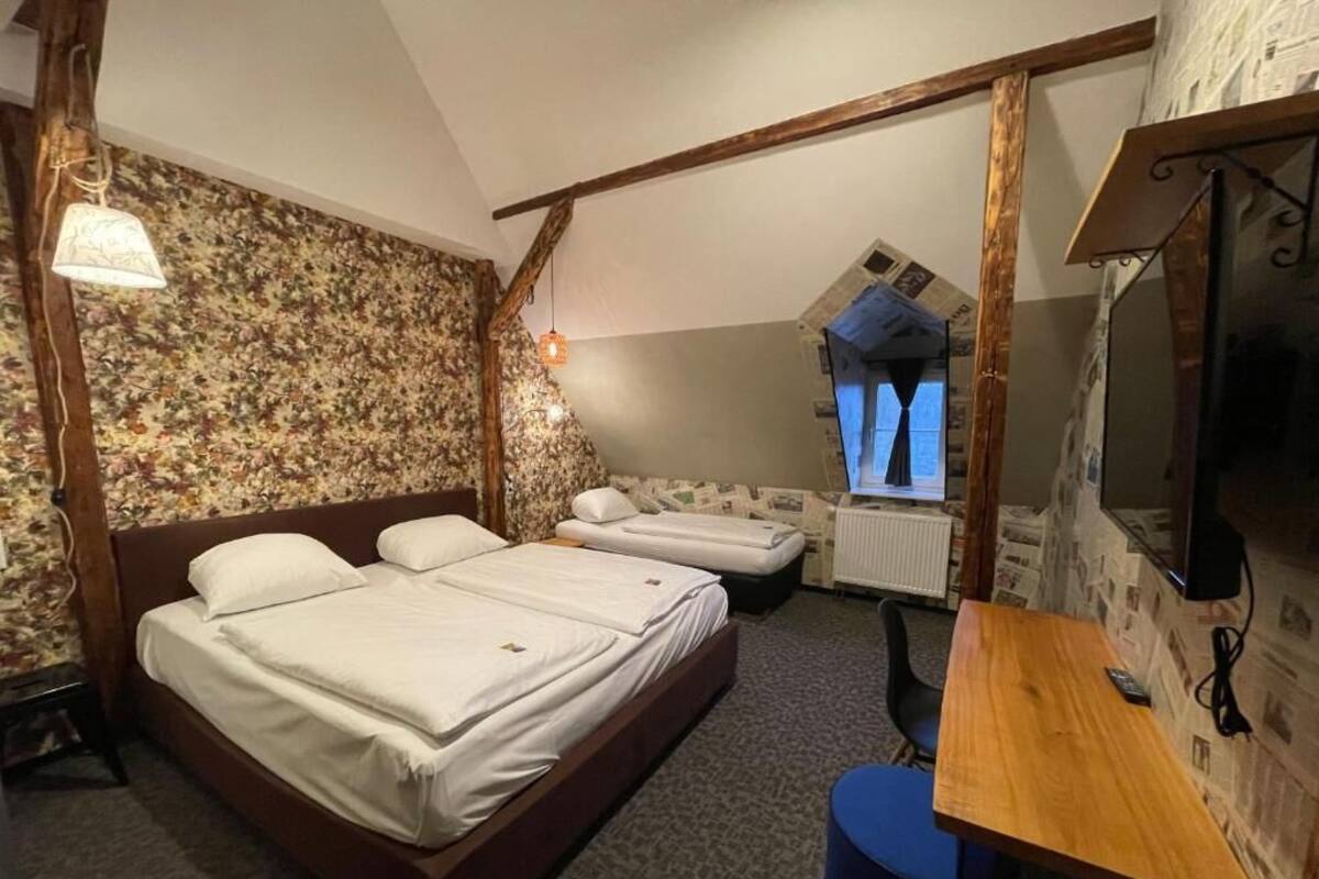 Un dormitorio con una cama grande, un escritorio y un televisor.