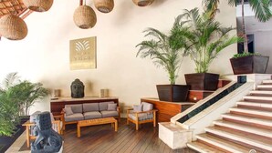 Un interior moderno con suelo de madera, una escalera y una zona de sofás.