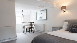 Ein modernes Schlafzimmer mit Bett, Nachttischen, Schreibtisch und Stuhl.