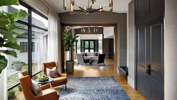 A modern interior with a dining area, a large window, and a chandelier.